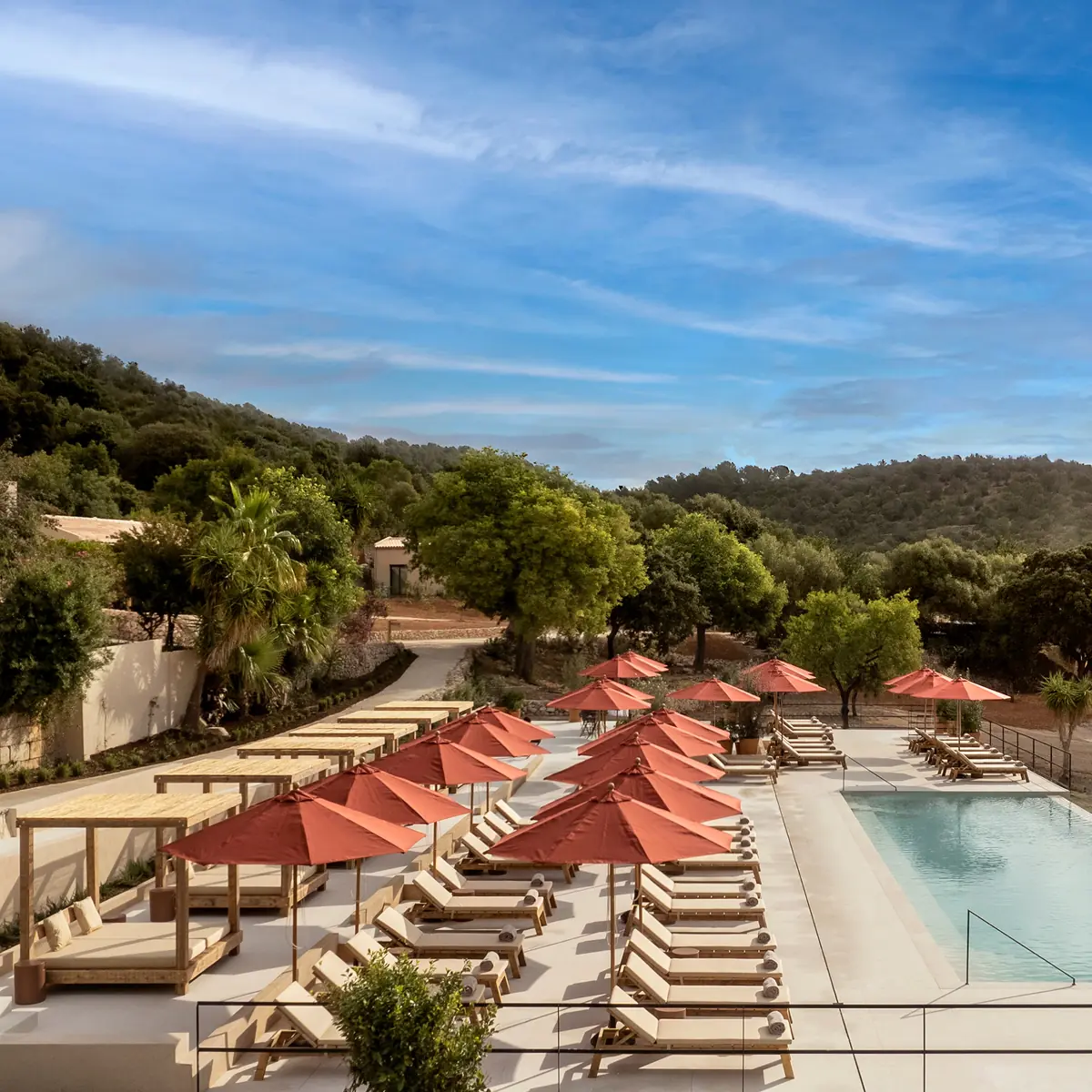 Piscina de The Lodge con hamacas y sombrillas
